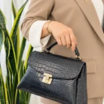 کیف دستی زنانه صندوقی مشکی طرح کروکودیل با یراق طلایی نمای جلو